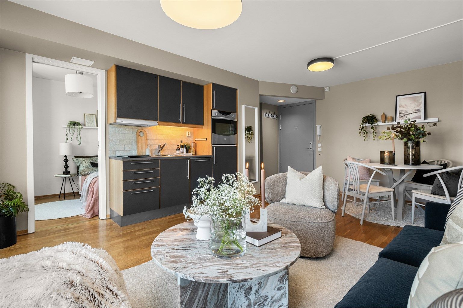 Kjøkkenet ligger naturlig tilbaketrukket og er innredet med mørke slette fronter og benkeplate av laminat. 