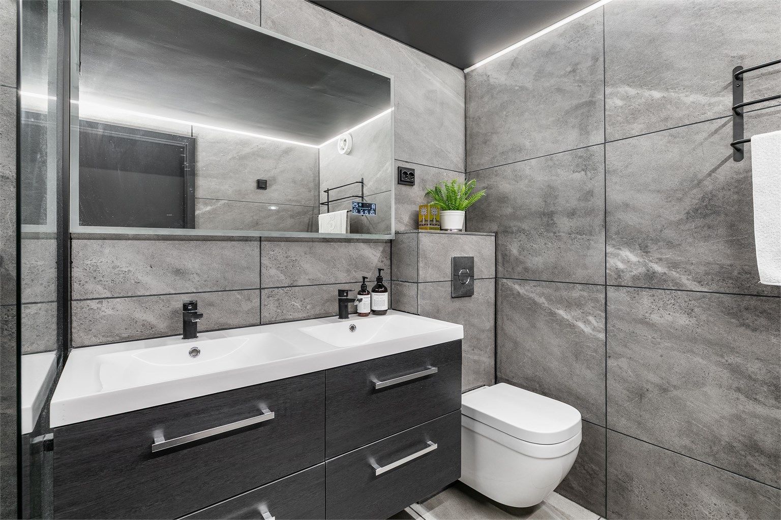 Badet ble renovert i 2020 og er like gjennomtenkt som resten av leiligheten. Dobbel servant gjør det enkelt for to personer å benytte badet samtidig.
