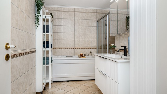 Badet i hovedetasjen har flislagt gulv med gulvvarme og flislagte vegger