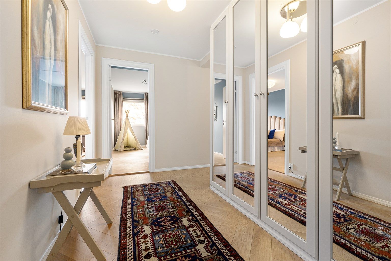 Gjennomgående parkett i fiskebeinsmønster binder rommene elegant sammen.