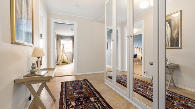 Gjennomgående parkett i fiskebeinsmønster binder rommene elegant sammen.