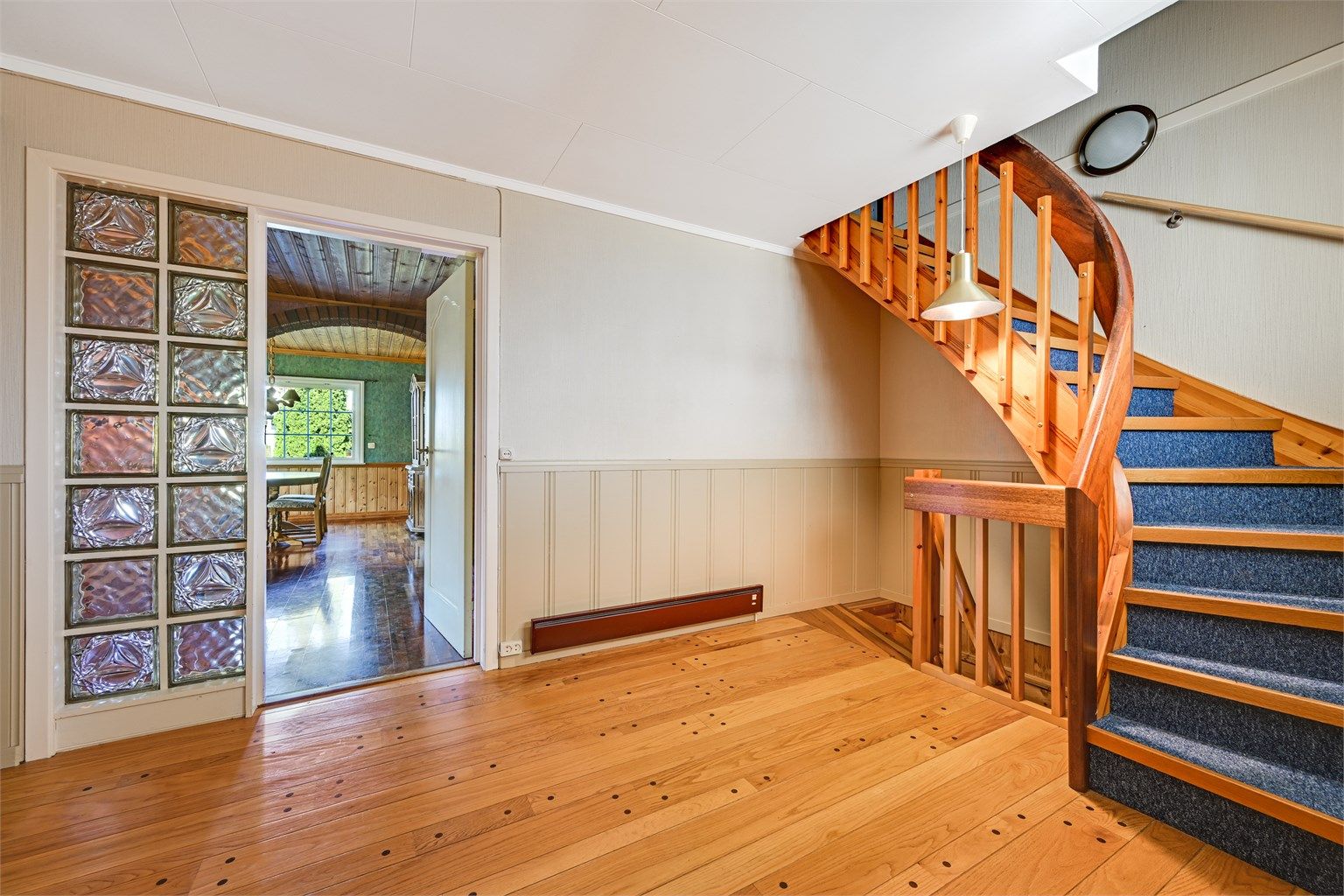 En lakkert tretrapp med teppebelegg forbinder etasjene.