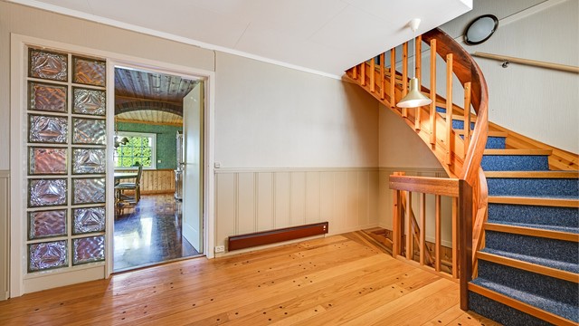 En lakkert tretrapp med teppebelegg forbinder etasjene.