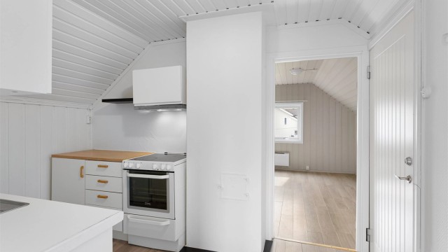 Kjøkkenet i 3. etasje har over- og underskap i hvit samt glatt utførelse.