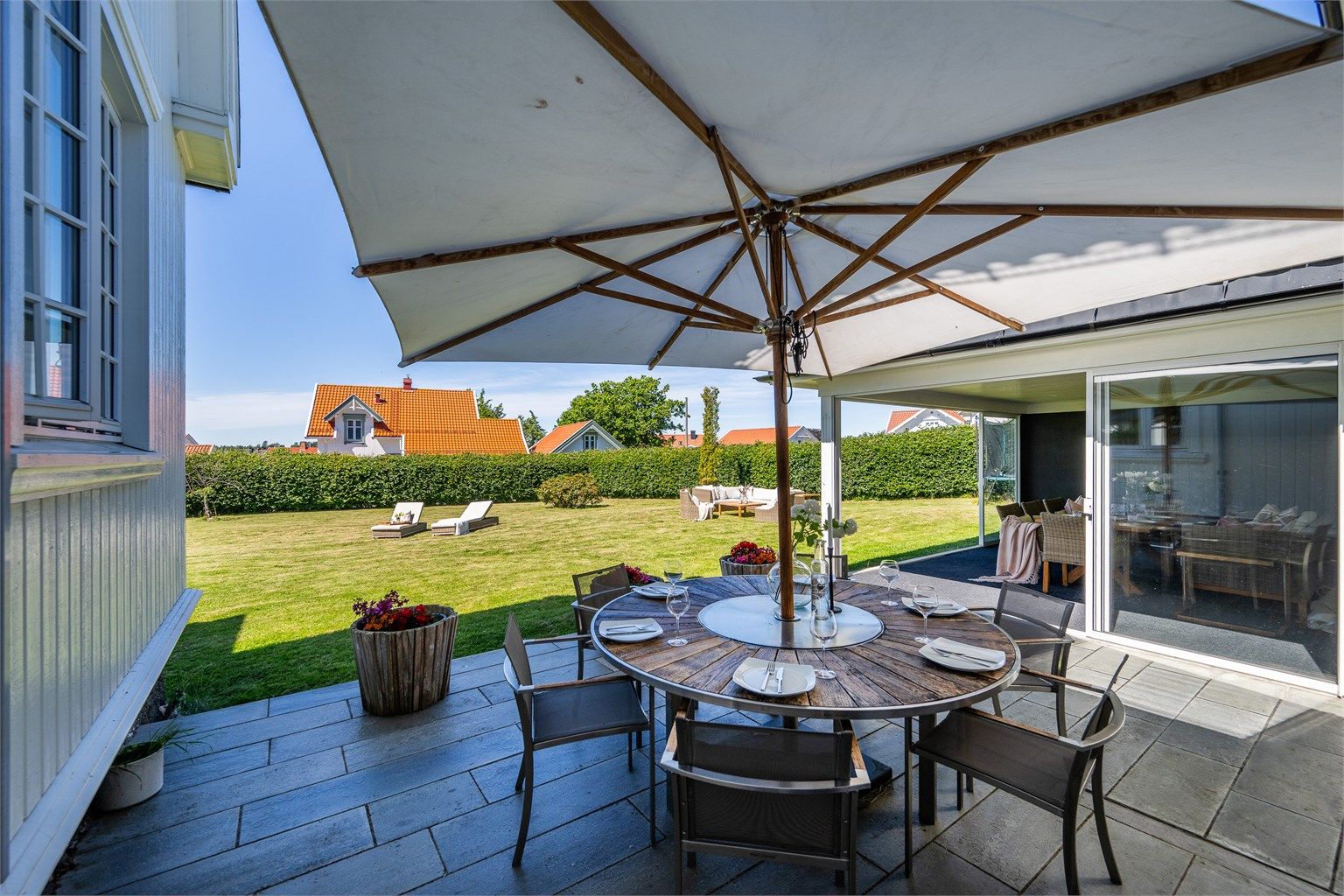 Fra gangen har du både utgang til gårdsplass og tilgang til en fantastisk uteplass med skiferterrasse og en lun, innglasset sommerstue