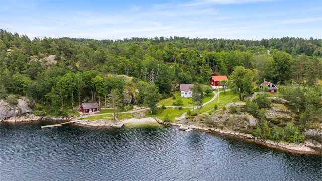 Eiendommen har egen sandstrand, brygger og en samling sjarmerende bygninger omsluttet av tett skog og berg