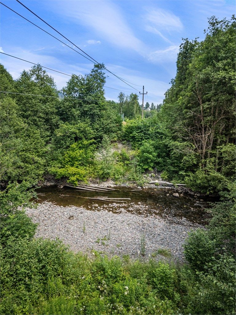 Elven som renner langs tomtegrensen skaper en idyllisk ramme rundt eiendommen.