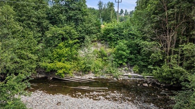 Elven som renner langs tomtegrensen skaper en idyllisk ramme rundt eiendommen.