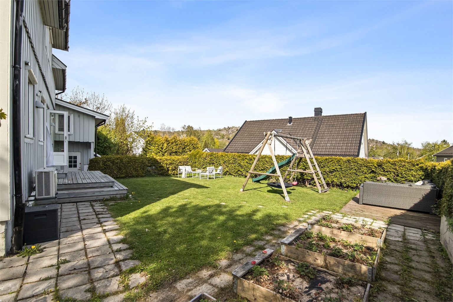 Tomten er opparbeidet med plen, belegningsstein og diverse beplantning.