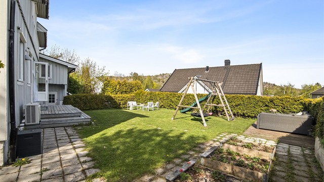 Tomten er opparbeidet med plen, belegningsstein og diverse beplantning.