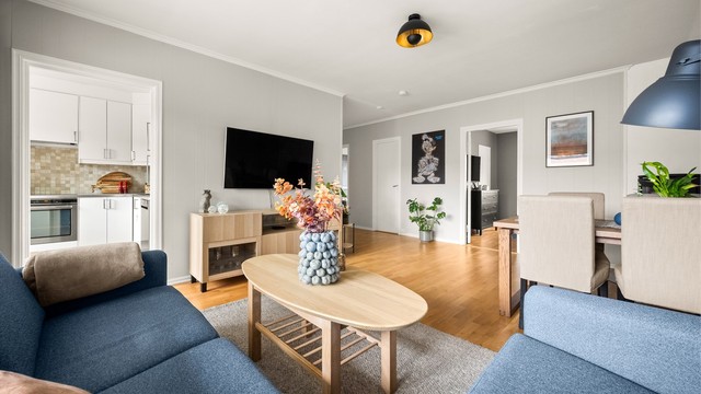 Gjennomgående parkettgulv binder rommene sammen og skaper en helhetlig og varm atmosfære i leiligheten.