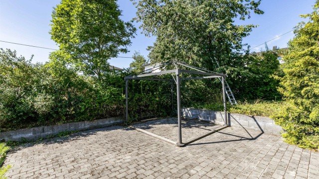Den store uteplassen er helhetlig utført med belegningsstein. Ramme til paviljong medfølger.