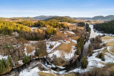 Småbruket grenser til elva Straumen som til slutt munner ut i Telemarkskanalen.