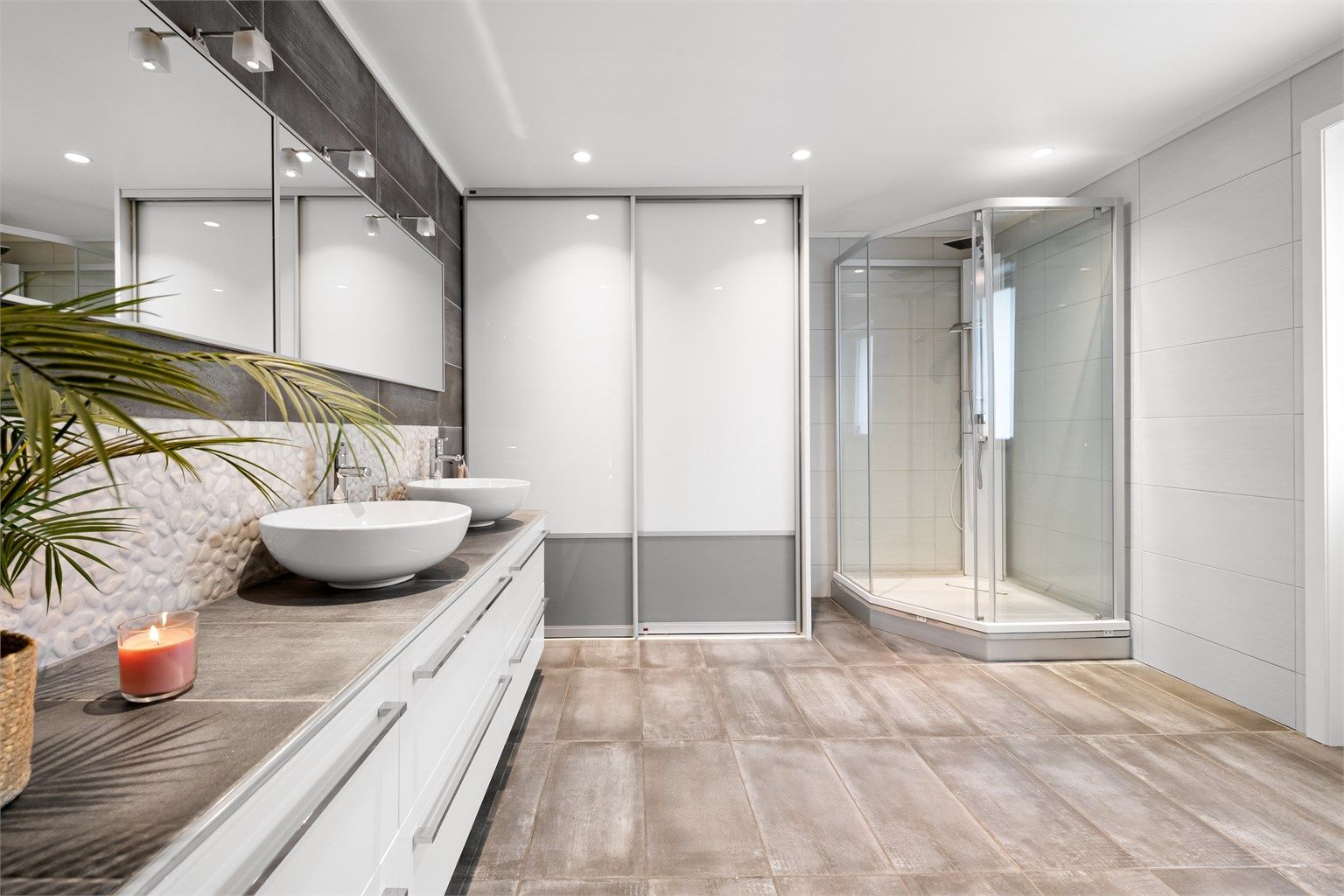 En praktisk skyvedørsgarderobe gir rikelig med lagringsplass på badet.