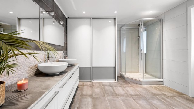 En praktisk skyvedørsgarderobe gir rikelig med lagringsplass på badet.