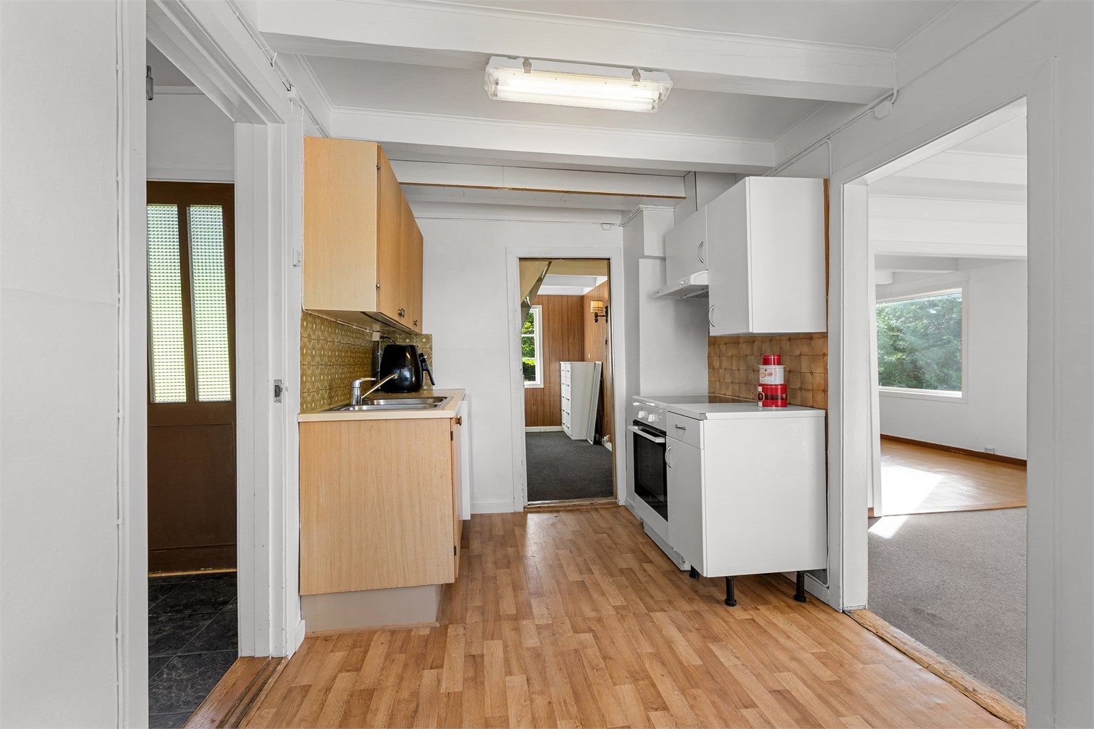 Kjøkkenet har innredning med finerfronter og benkeplate med laminert overflate.