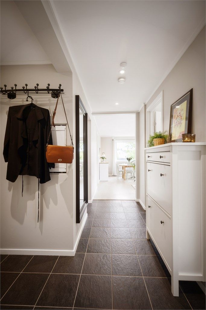 Lys og moderne gang med downlights, gulvvarme og gode oppbevaringsmuligheter - en naturlig og stilren overgang til boligens øvrige rom