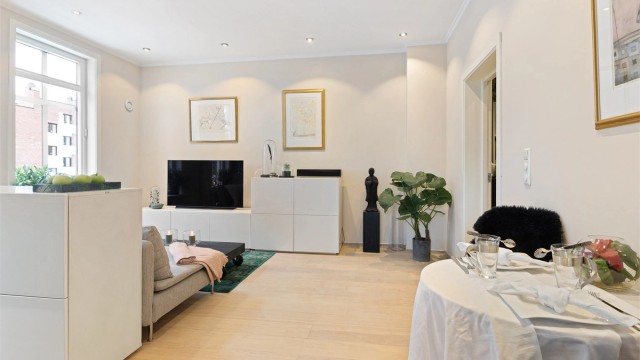 Leiligheten har parkett på gulv og malte flater. Downlights i himlingen gir god og jevn belysning i oppholdsrommet.