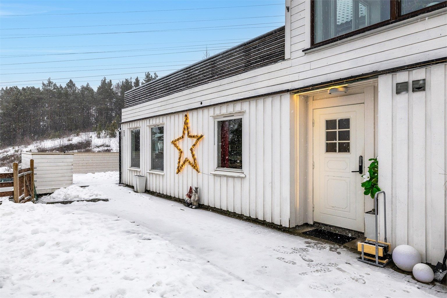 Inngjerdet hageområde med gangvei av belegningsstein.