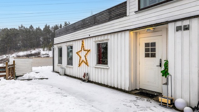 Inngjerdet hageområde med gangvei av belegningsstein.