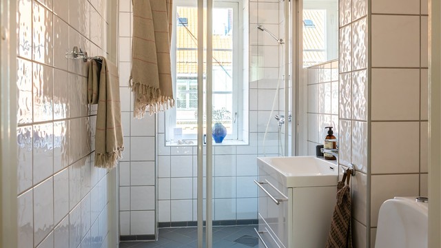 Baderommet har lyse og tidløse fliser på både vegger og gulv (elektrisk varme i gulv). Vindu gir naturlig dagslys og bidrar til en åpen og frisk atmosfære.