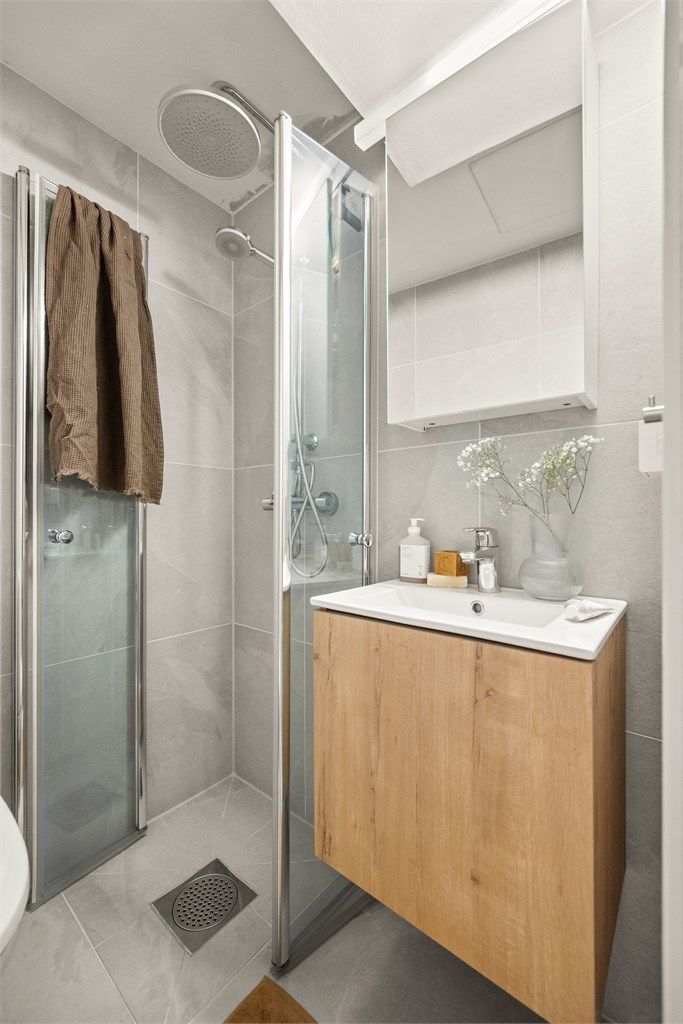 Dusjhjørne med svingbare glassdører.