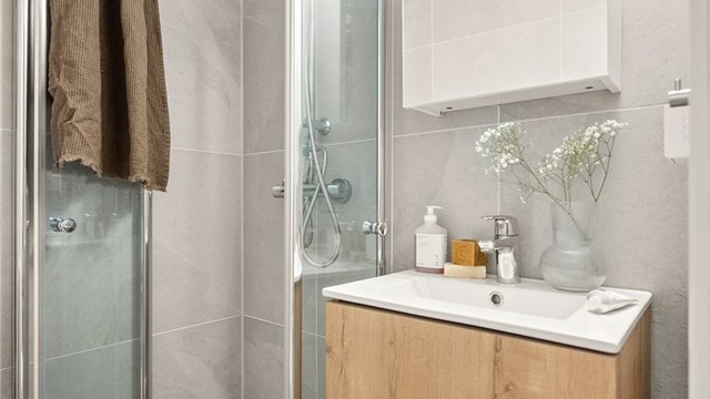 Dusjhjørne med svingbare glassdører.