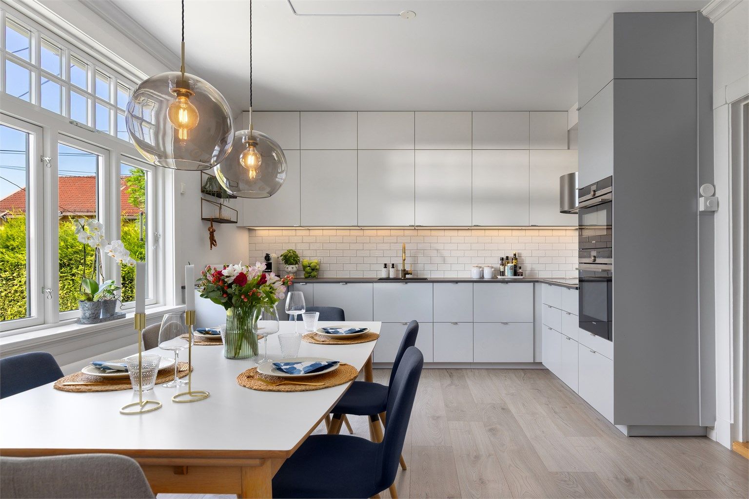  Lekker, lys og moderne Ikea kjøkkeninnredning fra 2017 med slette fronter og tidsriktig tynn benkeplate med senket kum fra Kvik kjøkken.