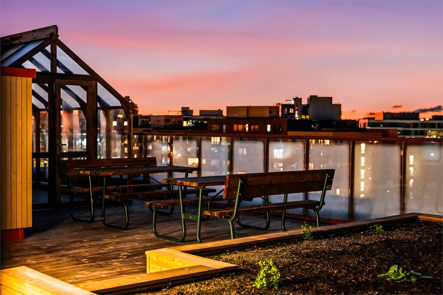 Fellestakterrasse med sittegrupper, drivhus og annet beplantning.
