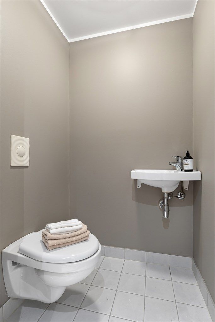 Leiligheten har et praktisk, separat toalettrom med vegghengt toalett og servant.