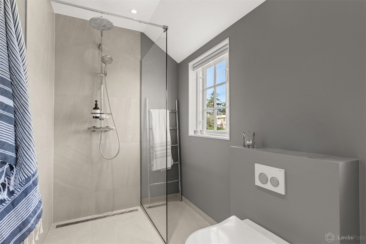 Dusjhjørne med glassvegg og dusjarmatur tilkoblet både hånddusj og regnfallsdusj