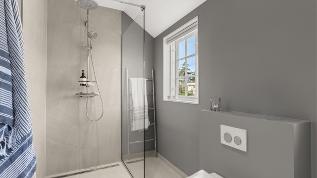 Dusjhjørne med glassvegg og dusjarmatur tilkoblet både hånddusj og regnfallsdusj