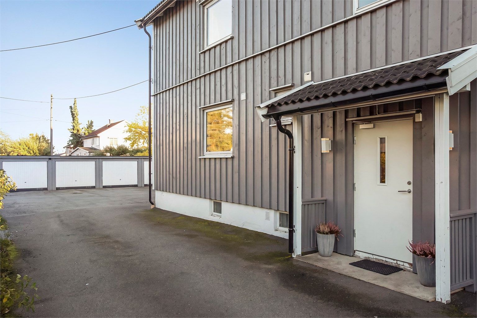 Overbygget inngangsparti som leder inn til felles trapperom.