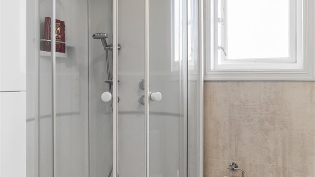 Rommet er innredet med dusjkabinett, servant med innredning og toalett, og har ventilasjon via vifte og ventil.