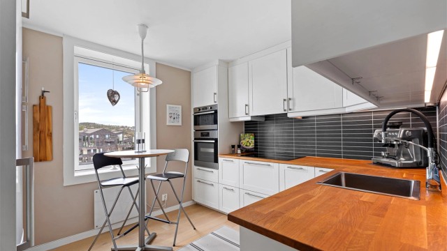 Kjøkken fra Ikea med rikelig skuff- og skapplass. Benkeplate i heltre. Det er integrerte hvitevarer som stekeovn, mikrobølgeovn, platetopp, oppvaskmaskin og kjøleskap.