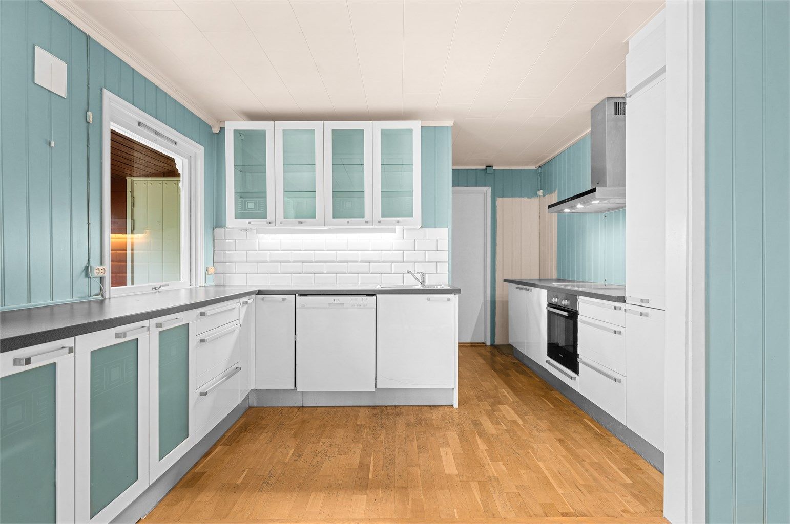 Et romslig kjøkken som har godt med skap- og benkeplass 