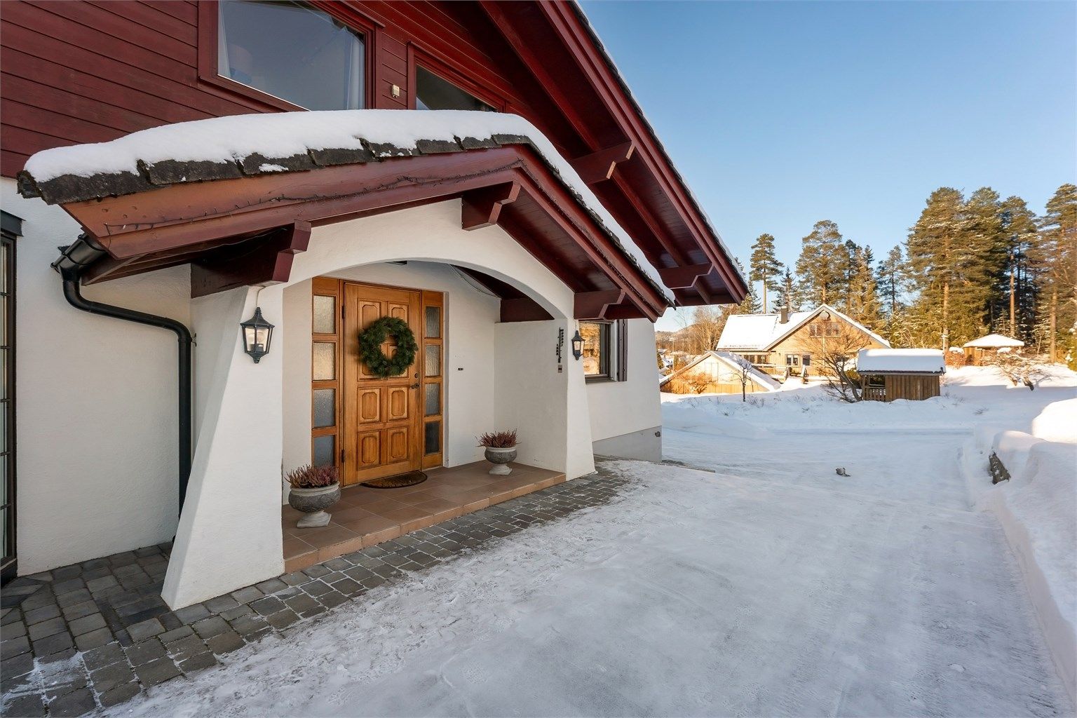 Yttervegger i tre- og betongkonstruksjoner, kledd med liggende trekledning og pussede flater.