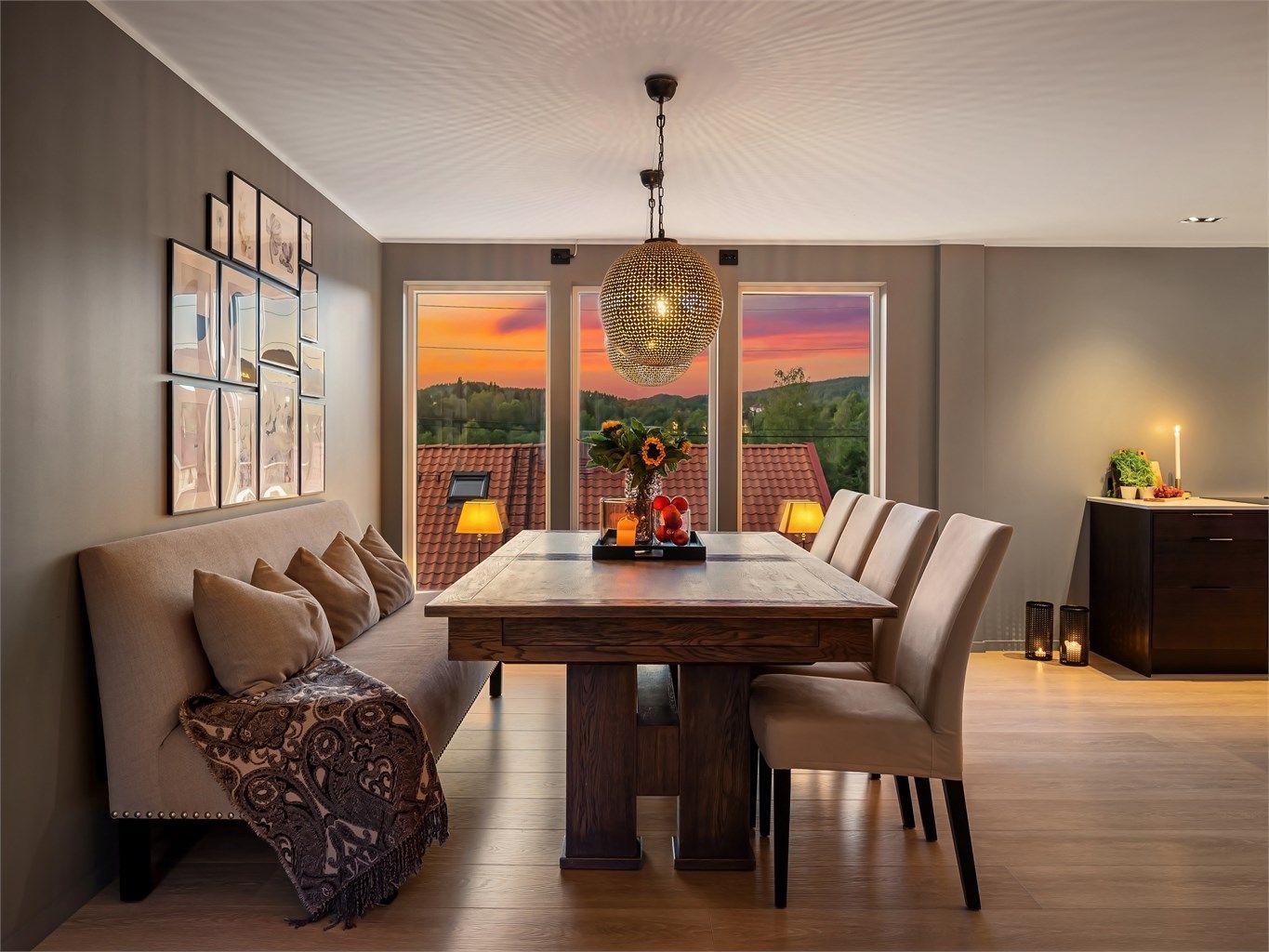 Boligen har en generøs spisestue i tilknytning til kjøkkenet og har hengende lyspendler med kuler, som gir et dekorativt og lunt uttrykk over spiseplassen