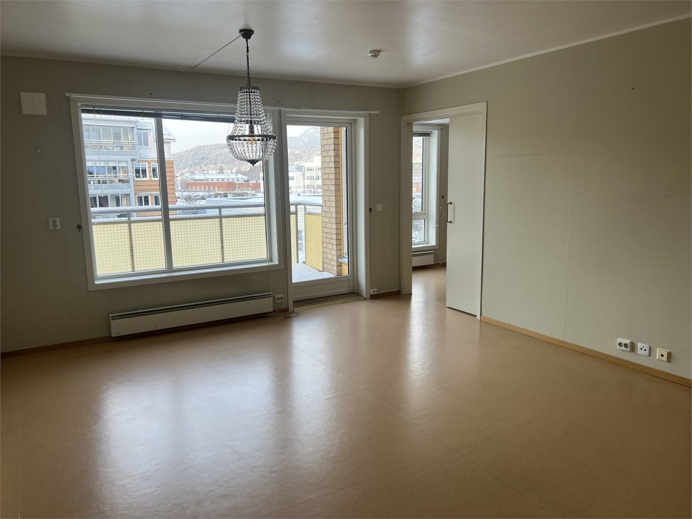 Romslig stue med vinylbelegg på gulv og malte flater på vegger