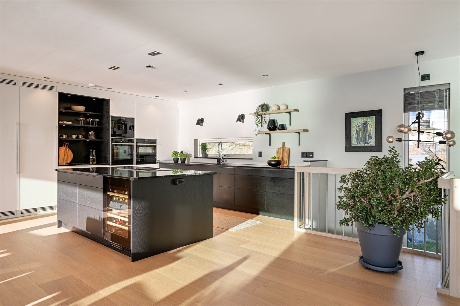 Kjøkkenet er moderne og svært delikat med mørk innredning og benkeplate av stein. 