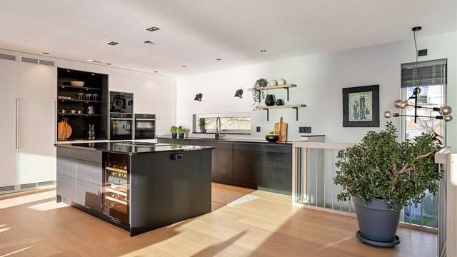 Kjøkkenet er moderne og svært delikat med mørk innredning og benkeplate av stein.