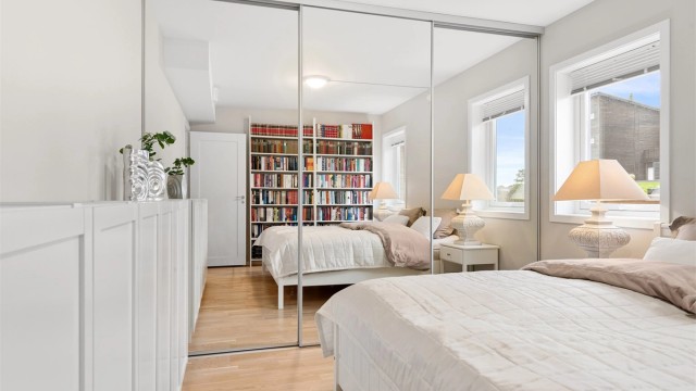 Romslig hovedsoverom med skyvedørsgarderobe