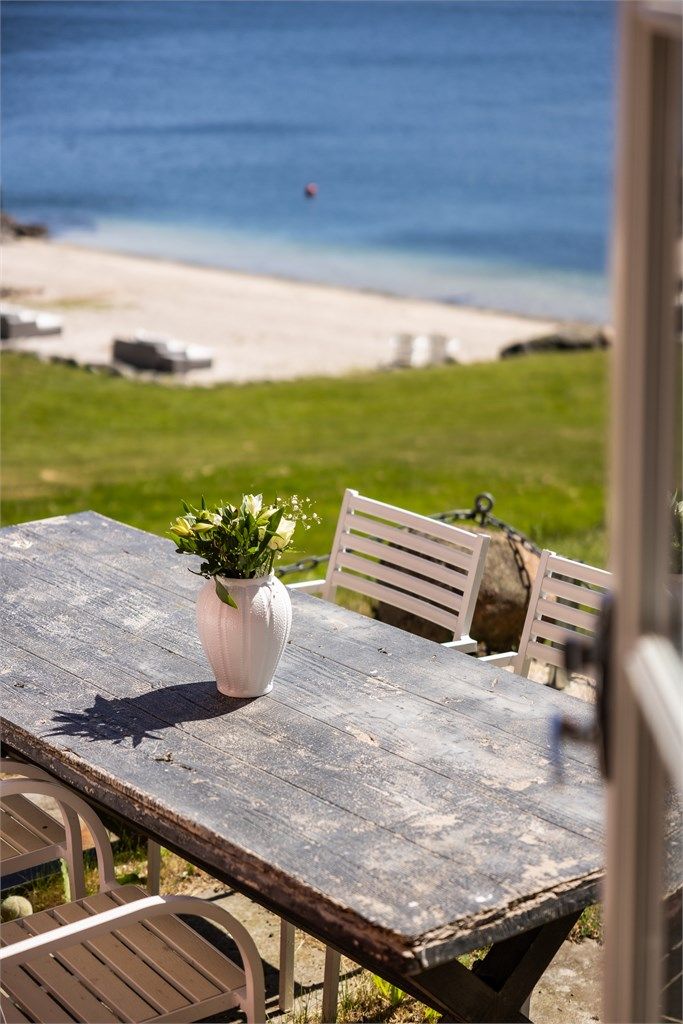 Nyt måltidene utendørs med utsikt mot den private stranden.