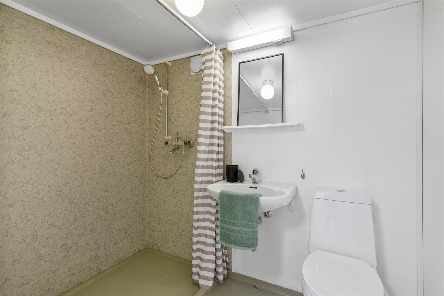 Bad i kjeller er av enkel standard. Dusjnisje, toalett, enkel servant, belegg på gulv og i dusjsone. 
