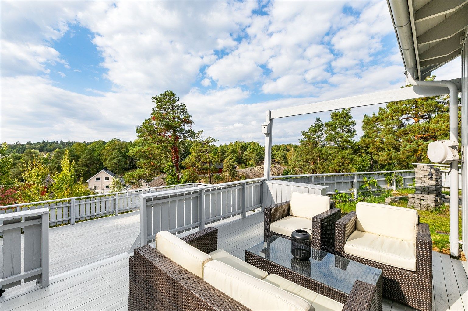 Store terrasser i to høyder er anlagt langs boligens vestre side, der fint utsyn sees i samme himmelretning.