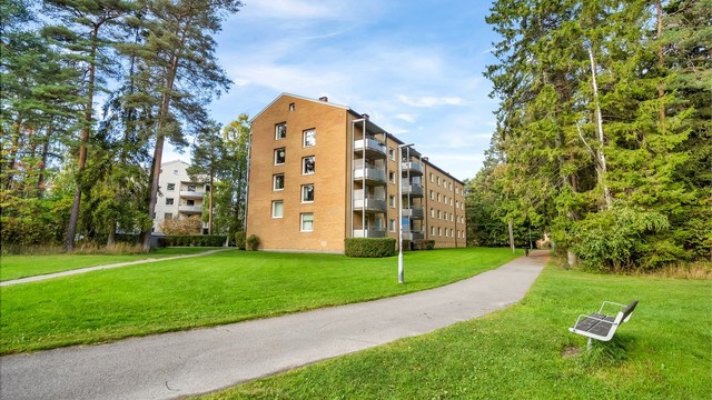 Borettslaget består av teglsteinsblokker plassert i et frodig og grønt parklandskap.
