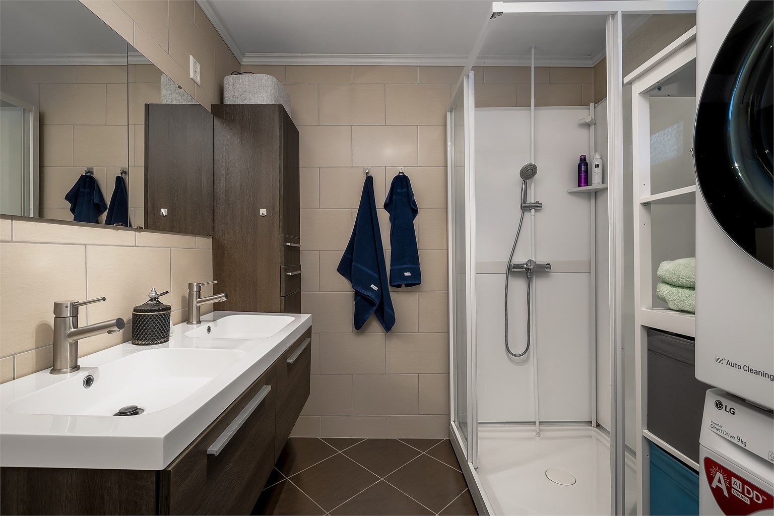 Badet er innredet med baderoms innredning med slette fronter og heldekkende servant, dusjkabinett, toalett og opplegg til vaskemaskin.