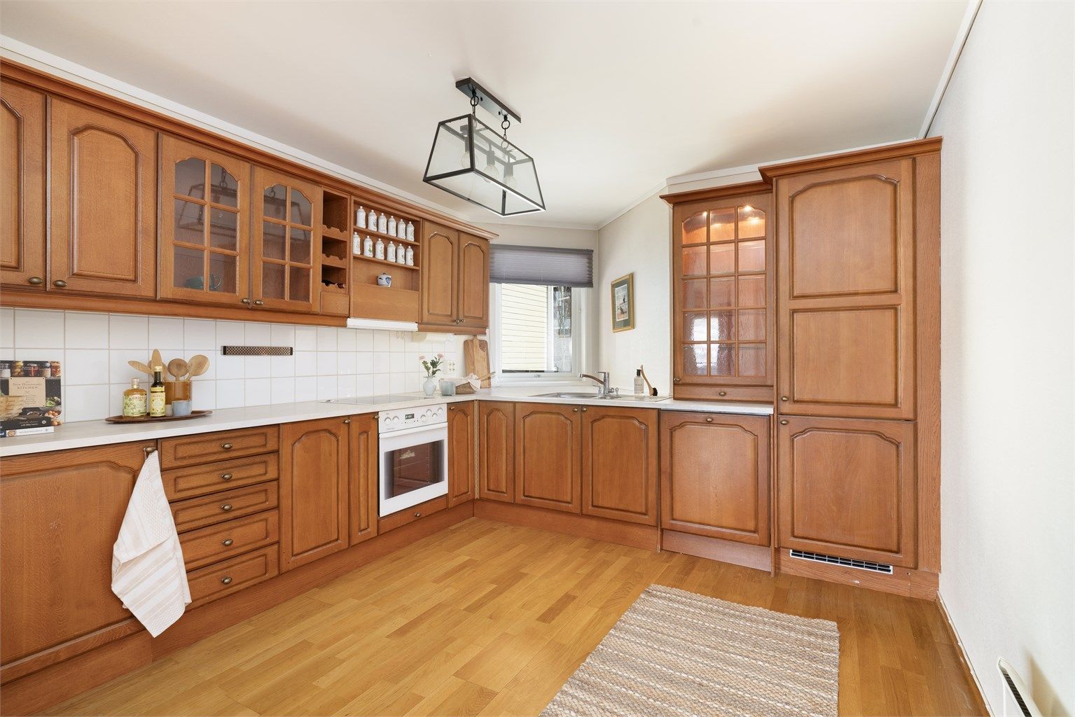 Kjøkkeninnredning fra byggeåret med profilerte fronter og godt med skap- og benkeplass.