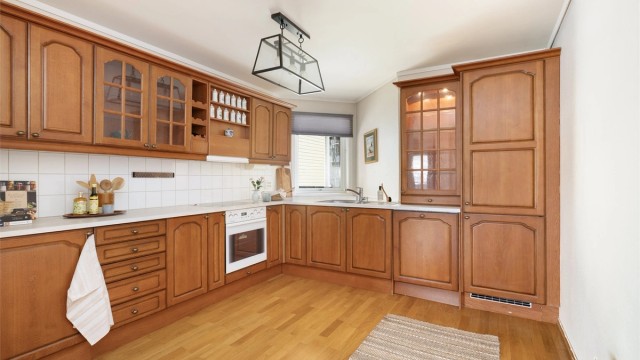 Kjøkkeninnredning fra byggeåret med profilerte fronter og godt med skap- og benkeplass.