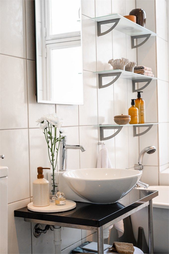 Baderomsinnredning med servant og speil. Badet har innfelte downlights i himlingen med malt panel.